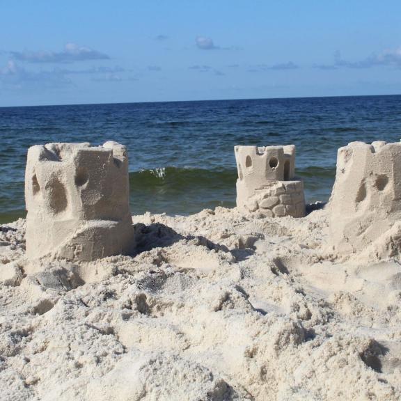 sandcastles in front of the Gulf built during a lesson from Sandcastle University